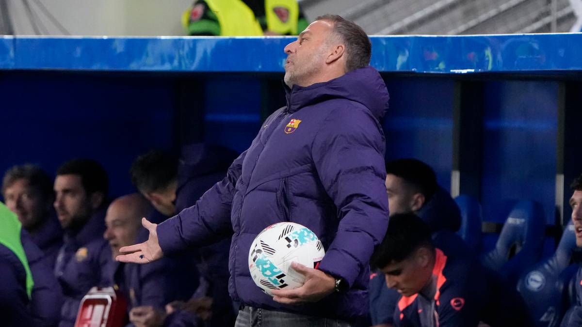 Trener FC Barcelony trzymający piłkę i gestykulujący do zawodnik&oacute;w siedzących na ławce rezerwowych.