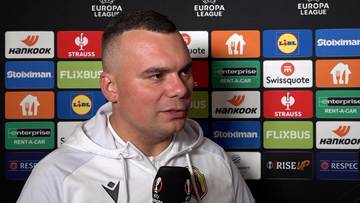 Trener Adrian Siemieniec podczas pomeczowego wywiadu na tle ścianki sponsorskiej