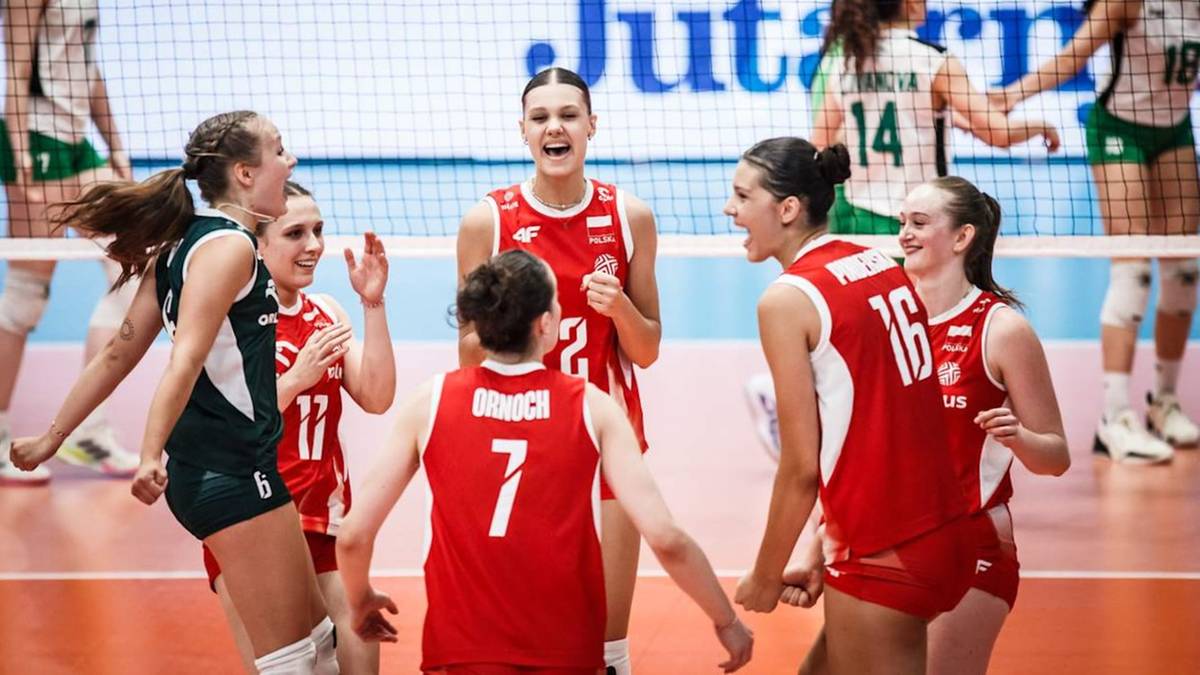 Grupa polskich siatkarek w czerwonych strojach świętuje zwycięstwo na boisku siatkarskim.