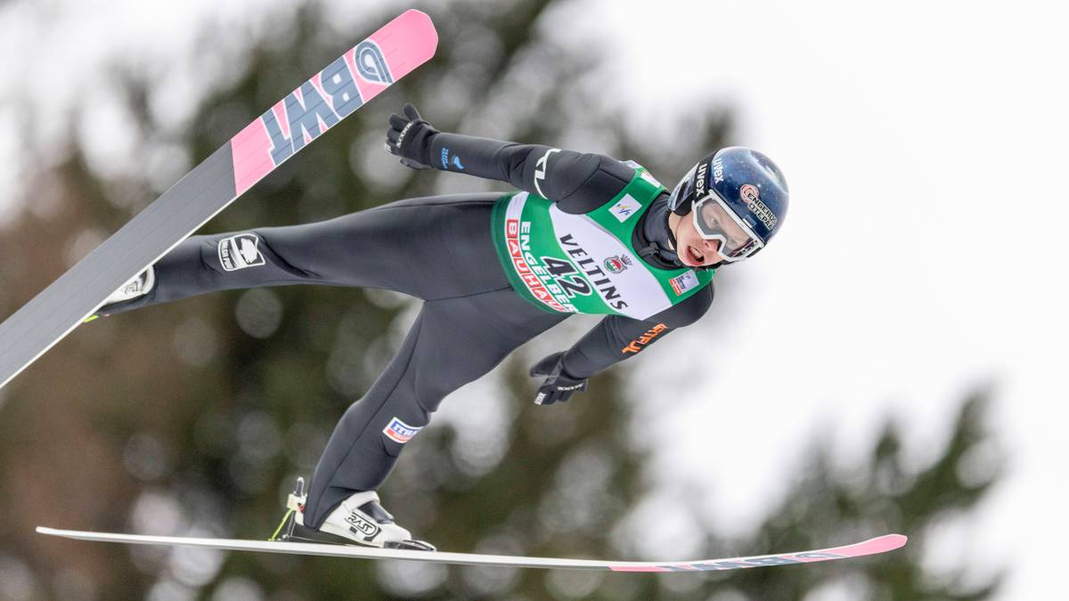 Skoczek narciarski w locie, wykonujący skok.