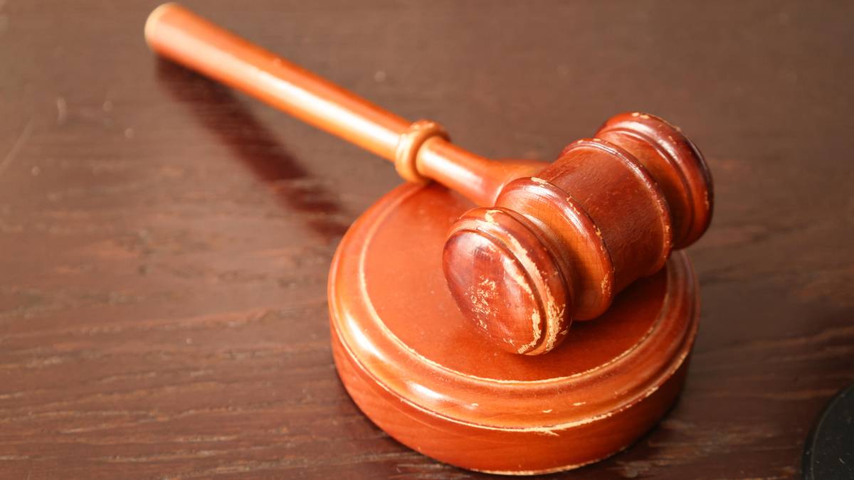 Drewniany młotek sędziowski na drewnianym podkładzie.