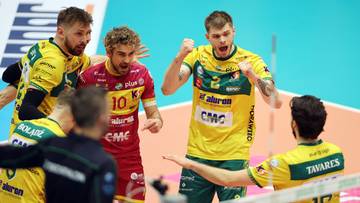 Siatkarze drużyny Aluron CMC Warta Zawiercie świętują podczas meczu, jeden z nich w czerwonej koszulce rozmawia z kolegą z drużyny.