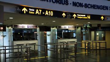 Tablice informacyjne na lotnisku w Wilnie wskazujące bramki A7-A10 i kontrolę paszportową.