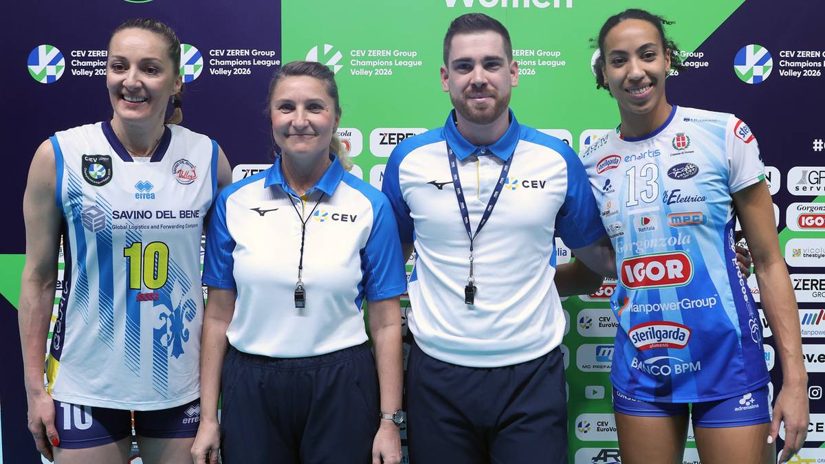 Cztery osoby, w tym dwie siatkarki, trener i arbiter, pozują do zdjęcia.