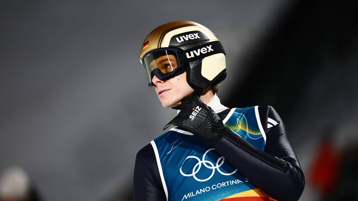 Skoczek narciarski w kasku i goglach podczas zawodów.