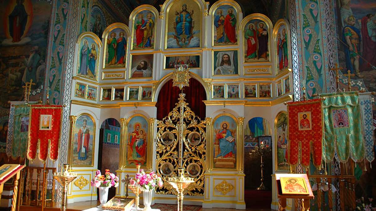 Ikonostas w cerkwi prawosławnej, bogato zdobiony złoceniami i ikonami świętych.