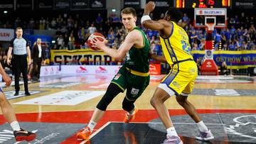 Dw&oacute;ch koszykarzy podczas meczu, jeden z nich pr&oacute;buje kozłować piłkę, drugi pr&oacute;buje mu ją odebrać.