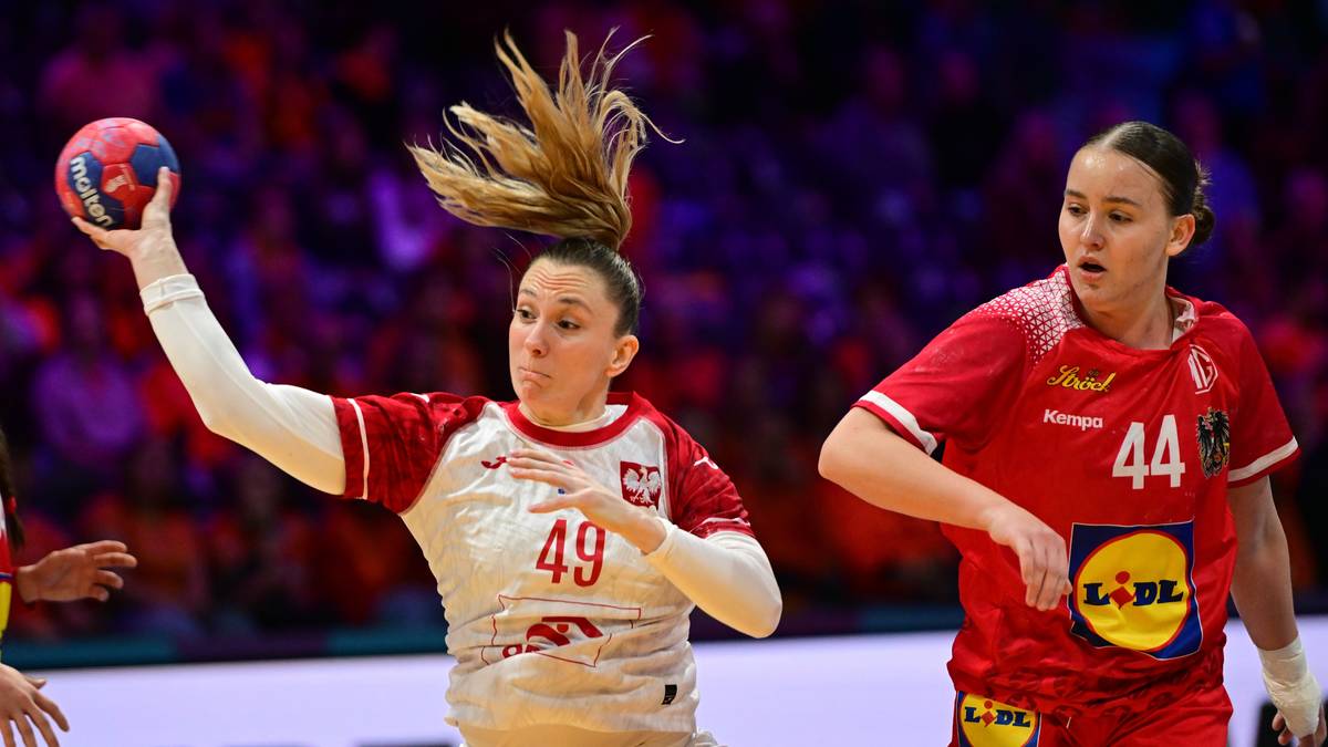 Piłkarka ręczna w białej koszulce z numerem 49 próbuje rzucić piłkę do bramki. Obok niej znajdują się inne zawodniczki.