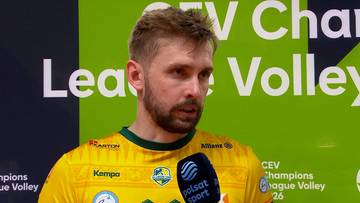 Siatkarz Mateusz Bieniek w żółtej koszulce udziela wywiadu, trzymając mikrofon Polsat Sport. W tle baner z logo CEV Champions League Volley.