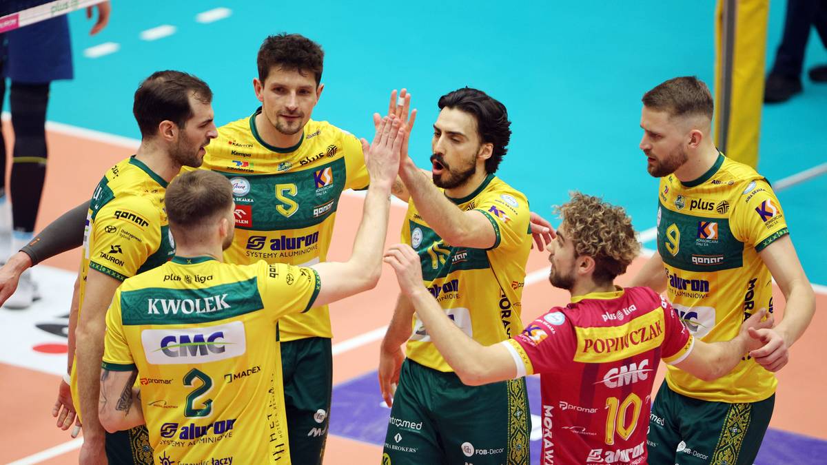 Siatkarze w ż&oacute;łtych koszulkach świętują zdobyty punkt, podając sobie piątki.