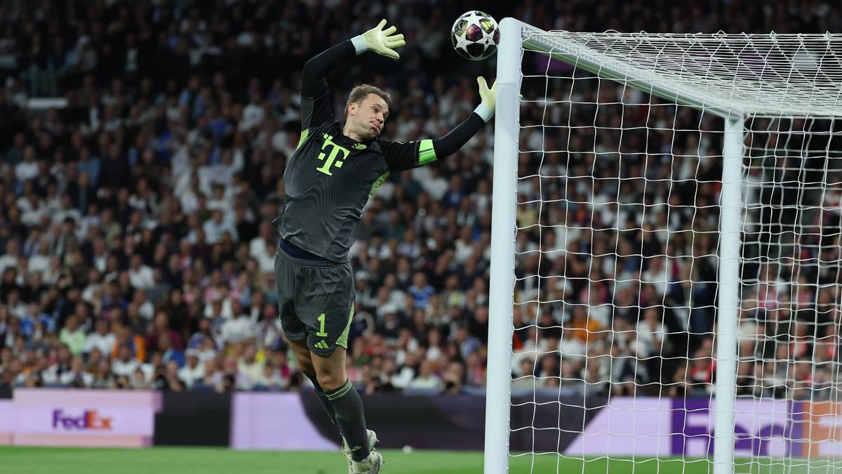 Bramkarz Manuel Neuer skacze do obrony piłki przy słupku bramki.