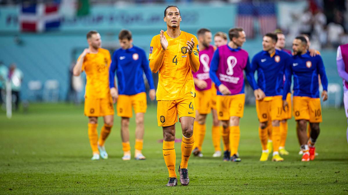 Virgil van Dijk prowadzi drużynę Holandii na boisko, ubrany w ż&oacute;łty str&oacute;j meczowy z numerem 4