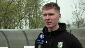 Michał Kolenda w czarnej bluzie z kapturem z herbem klubu na piersi, udziela wywiadu z mikrofonem Polsat Sport.