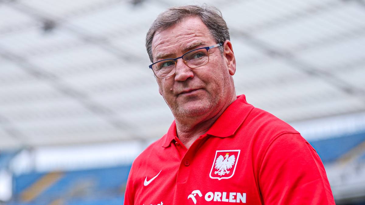 Portret mężczyzny w średnim wieku w czerwonej koszulce polo z herbem Polski na piersi i logo ORLEN.