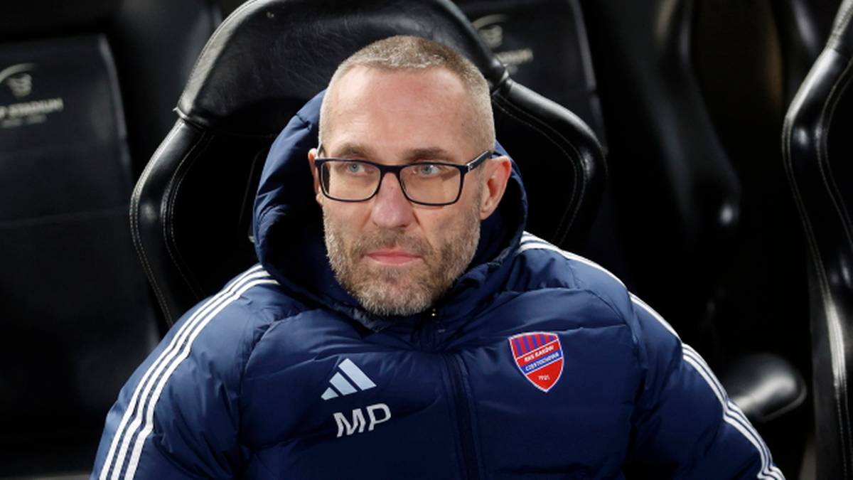 Marek Papszun, trener piłkarski, w okularach i kurtce z logo Rakowa Częstochowa.