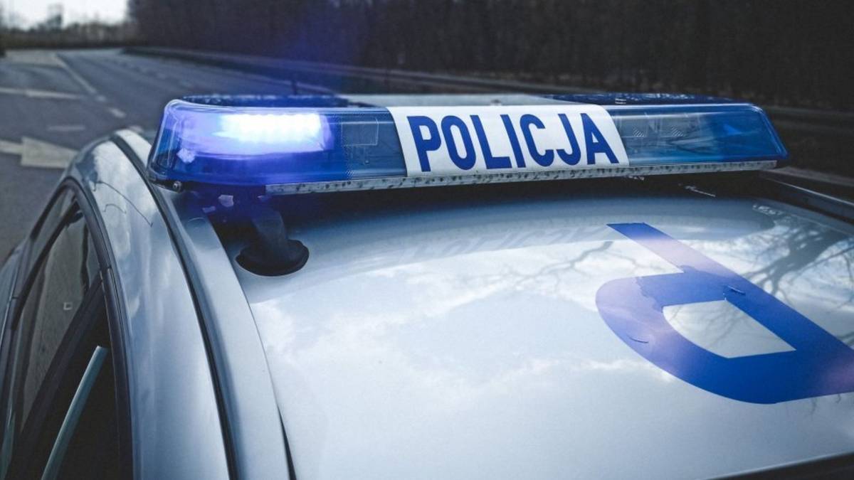 Niebieska belka świetlna z napisem POLICJA na dachu radiowozu.