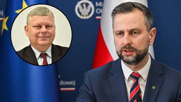 Zdjęcie przedstawia dw&oacute;ch mężczyzn. Na pierwszym planie, po prawej stronie, siedzi mężczyzna w garniturze i krawacie, m&oacute;wiący do mikrofonu. Na drugim planie, w okręgu, widoczny jest portret innego mężczyzny w garniturze.