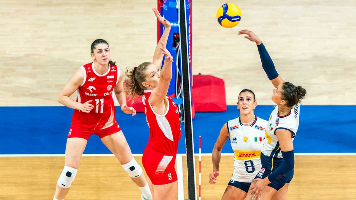 Siatkarki w akcji podczas meczu Polska - Włochy, jedna z zawodniczek blisko siatki próbuje zablokować atak przeciwniczki.