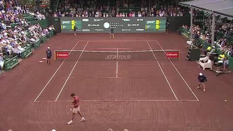 Dw&oacute;ch mężczyzn gra w tenisa na ceglanym korcie podczas meczu ATP Tour.