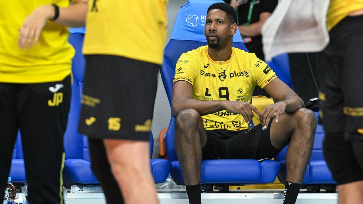 Siatkarz w ż&oacute;łtej koszulce z numerem 9 siedzi na ławce rezerwowych.