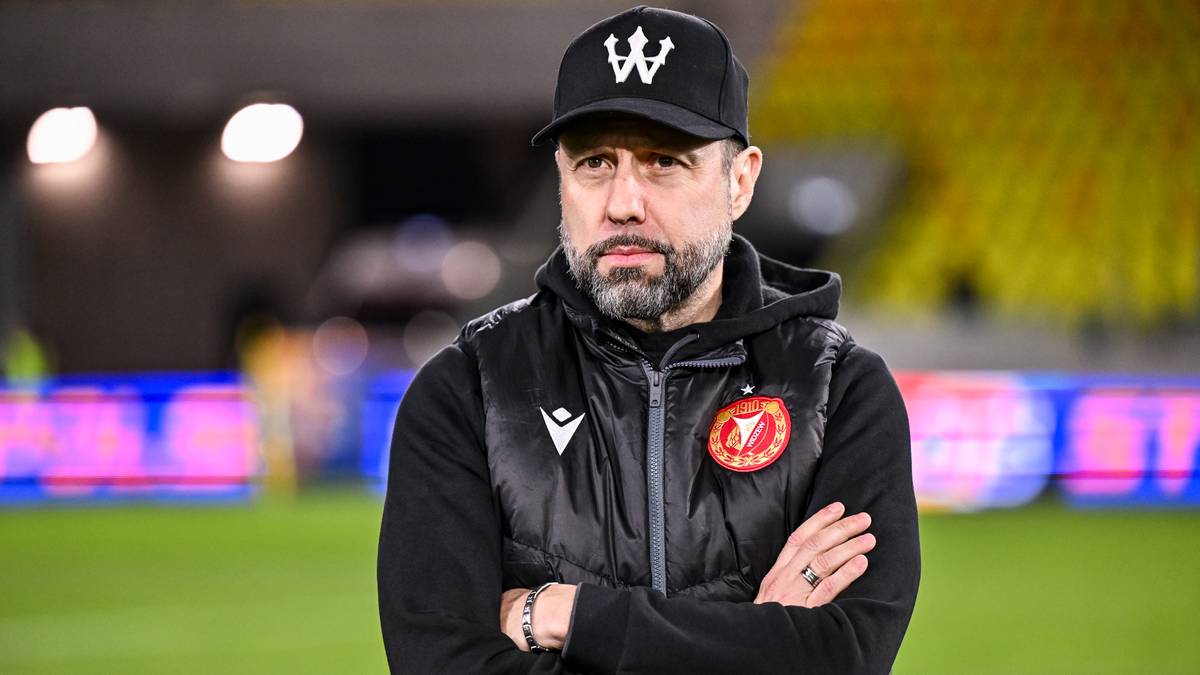 Mężczyzna w czapce i kamizelce na boisku piłkarskim