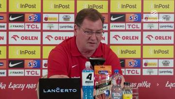 Jan Urban, trener piłkarski, siedzi za stołem podczas konferencji prasowej.