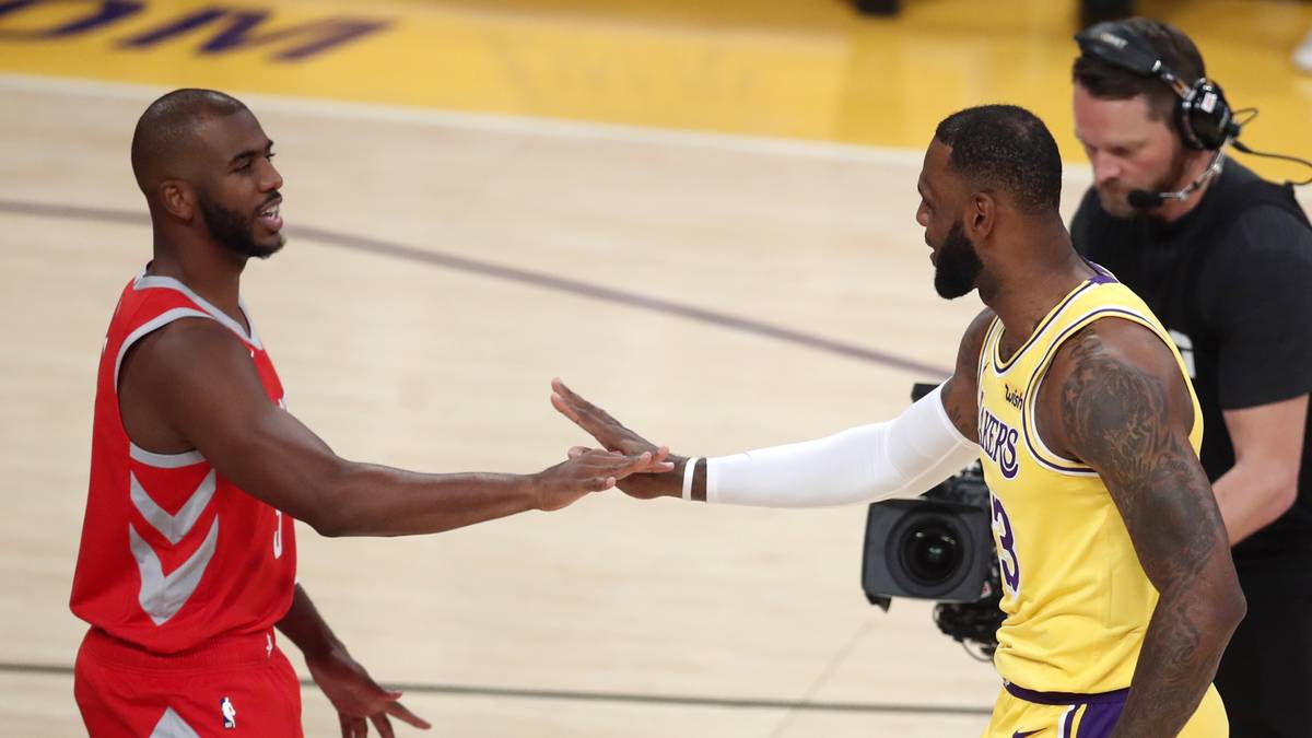 Dw&oacute;ch koszykarzy podaje sobie ręce na boisku podczas meczu.