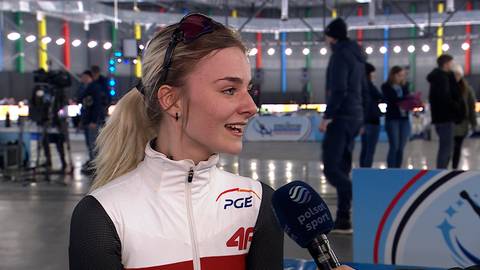 Hanna Mazur w stroju sportowym PGE z numerem 46, trzymająca mikrofon.