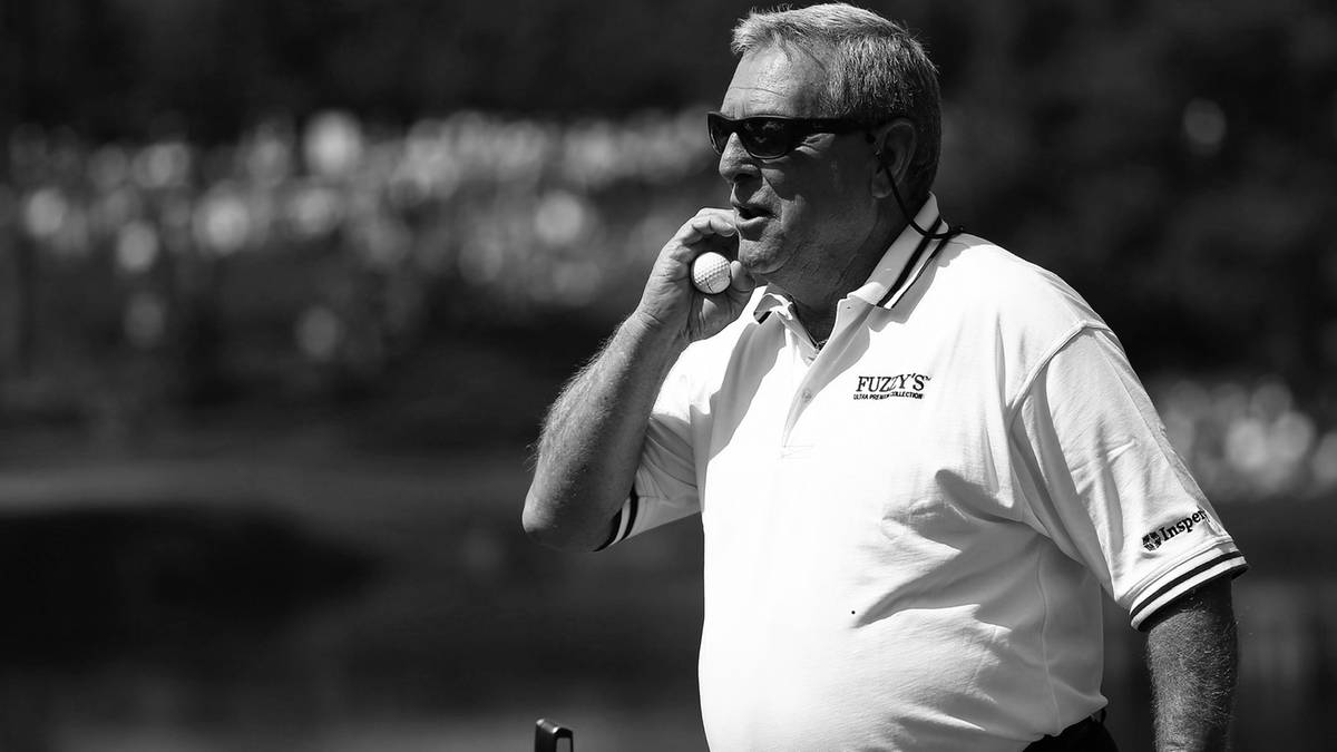 Fuzzy Zoeller, legendarny golfista, trzyma piłeczkę do golfa przy ustach.