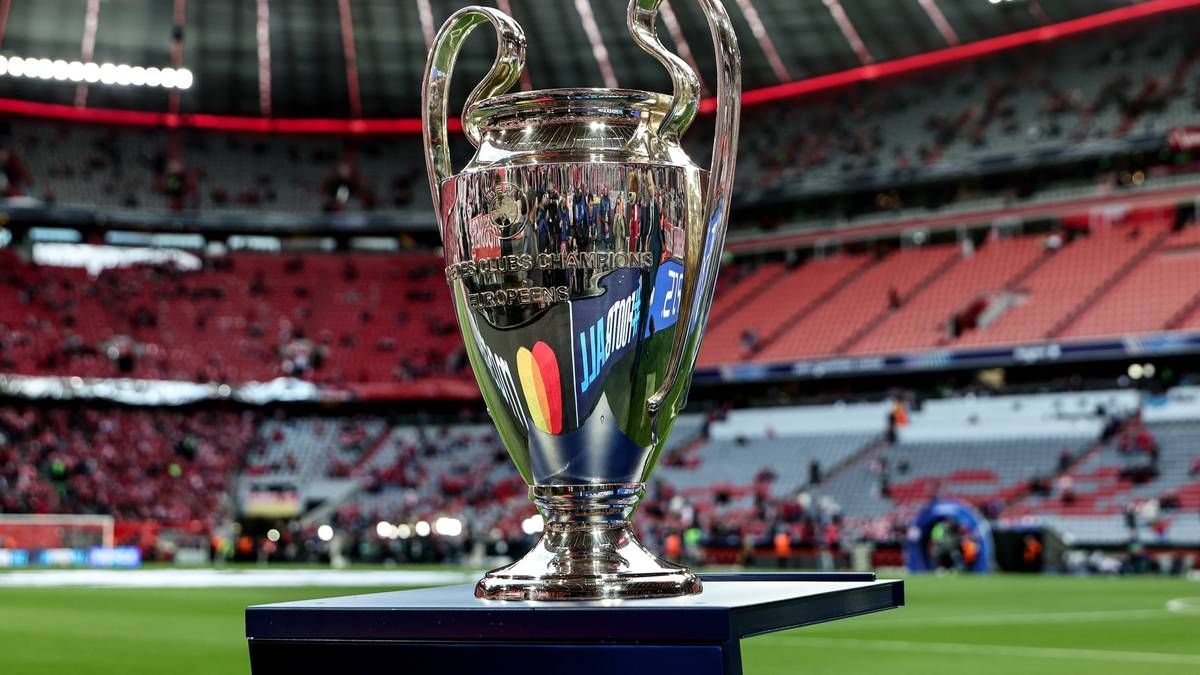 Trofeum Ligi Mistrz&oacute;w na tle trybun stadionu.