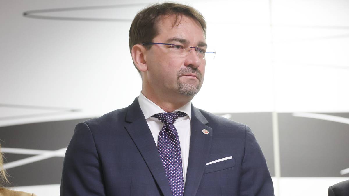 Portret mężczyzny w garniturze i okularach, prezesa polskiej federacji.