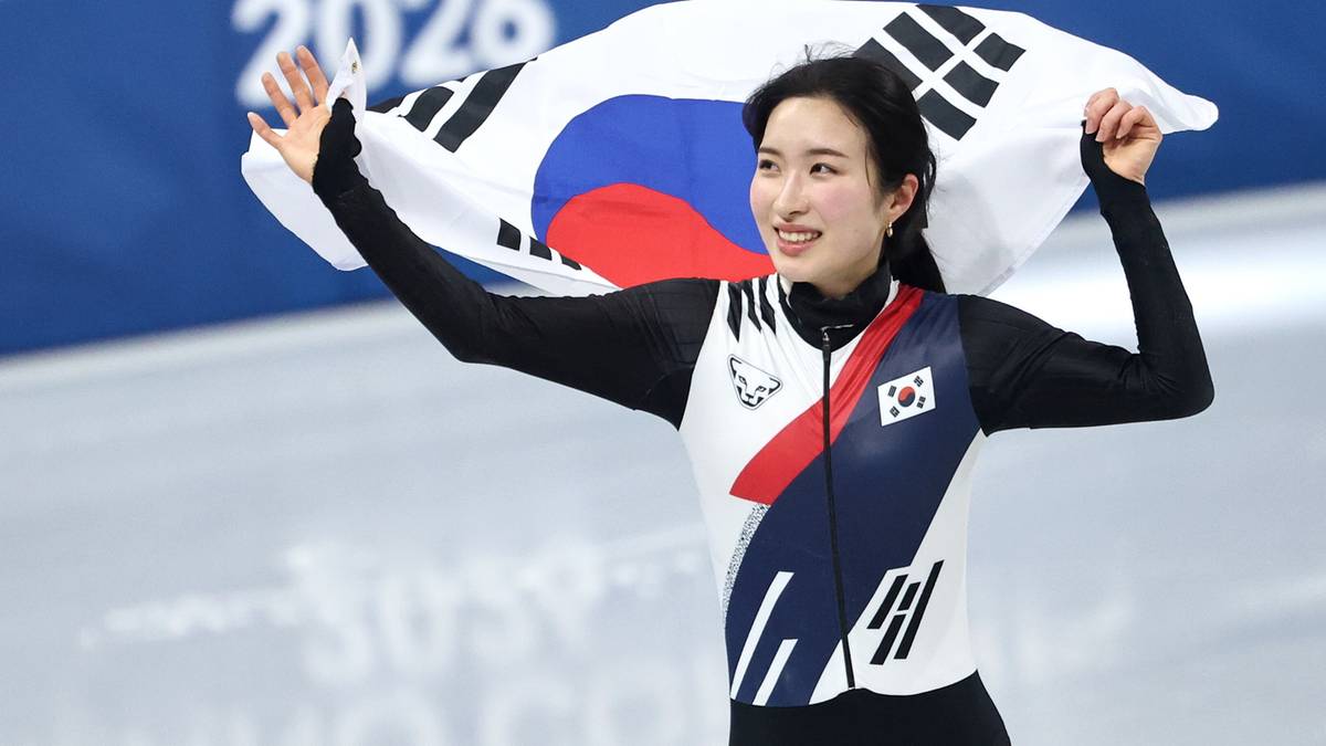 Zawodniczka short tracku z Korei Południowej trzyma flagę swojego kraju, ciesząc się ze zwycięstwa.