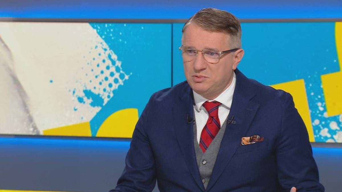 Poseł Konfederacji Przemysław Wipler w okularach i granatowym garniturze z czerwonym krawatem.