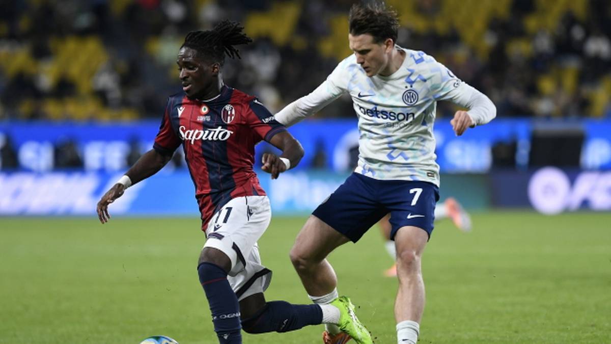 Dwóch piłkarzy rywalizujących o piłkę na boisku podczas meczu.