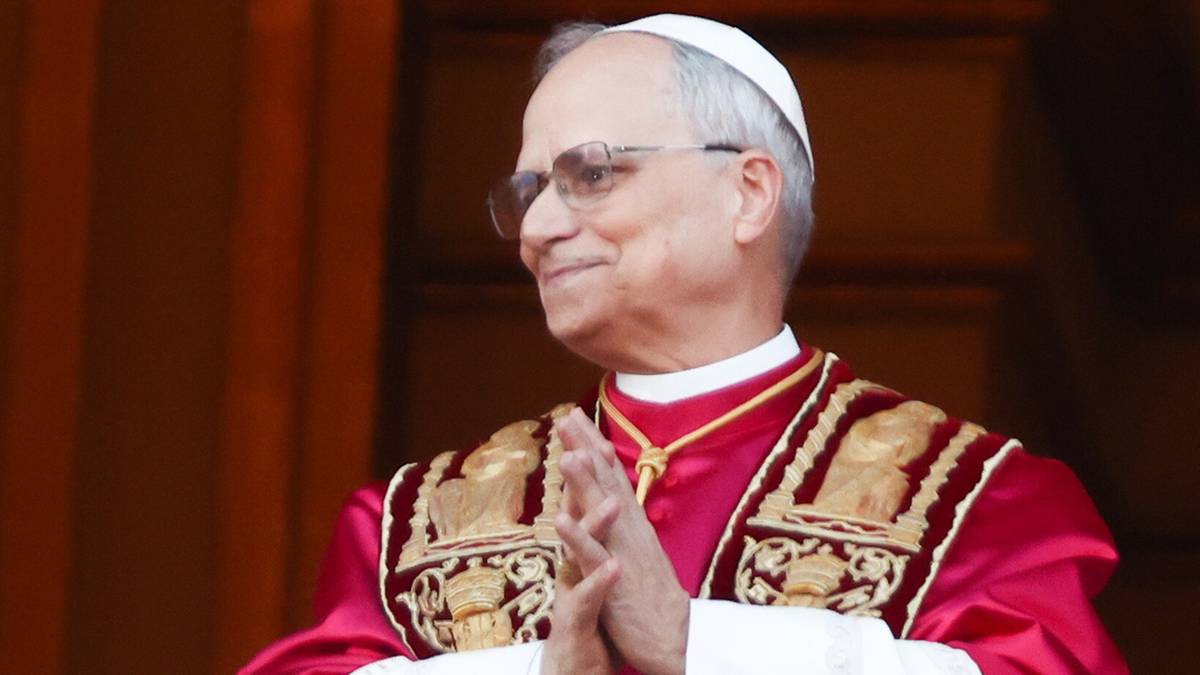 Portret mężczyzny w papieskiej soutannie i piusce, uśmiechającego się i klaszczącego.