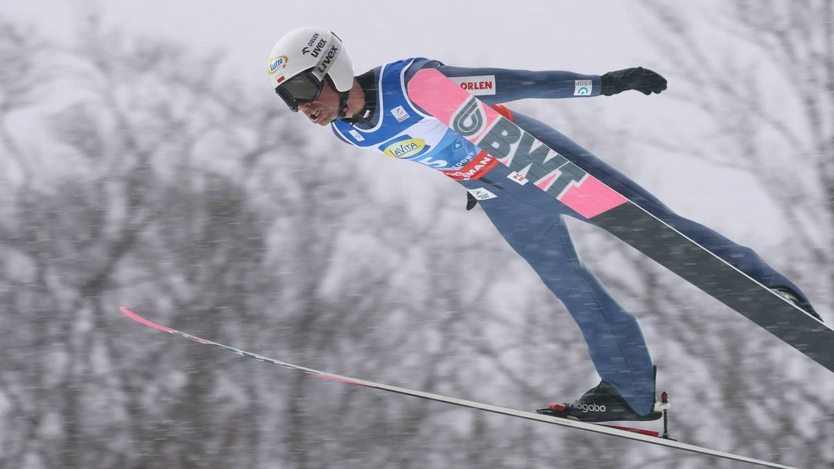 Skoczek narciarski w kombinezonie z logo BWT wykonuje lot na nartach.