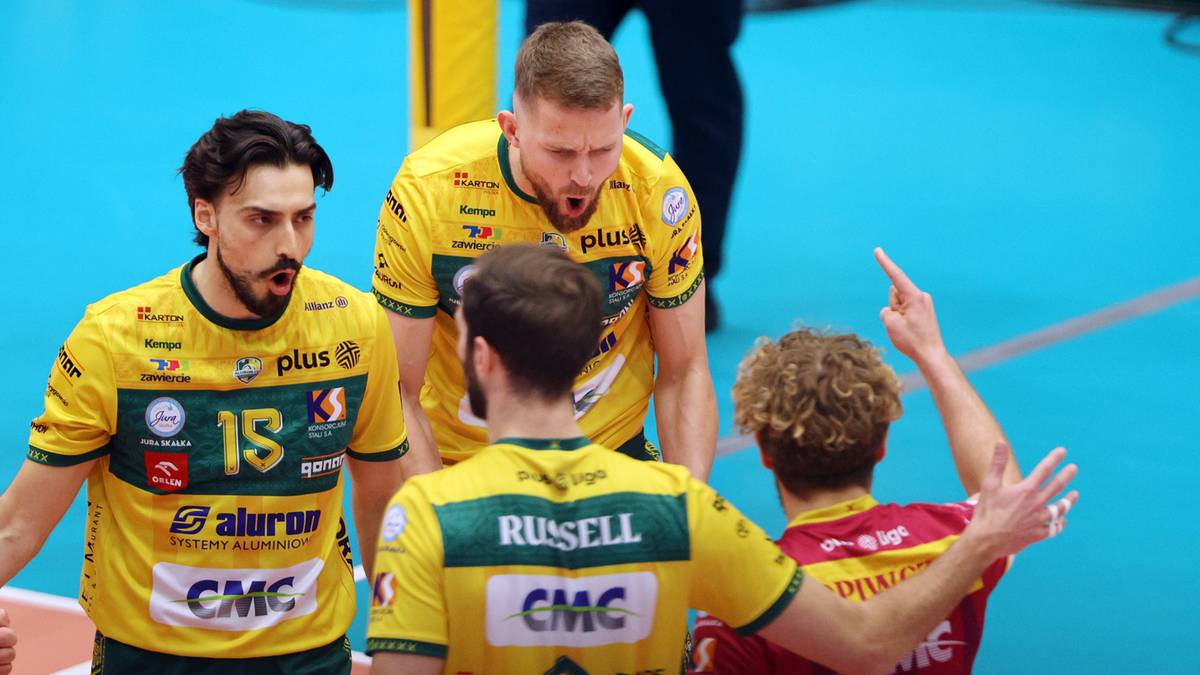 Czterech siatkarzy w strojach sportowych podczas meczu, dw&oacute;ch w ż&oacute;łtych z numerami 15 i 3, jeden w ż&oacute;łtej krzyczący, jeden w czerwonej gestykulujący.