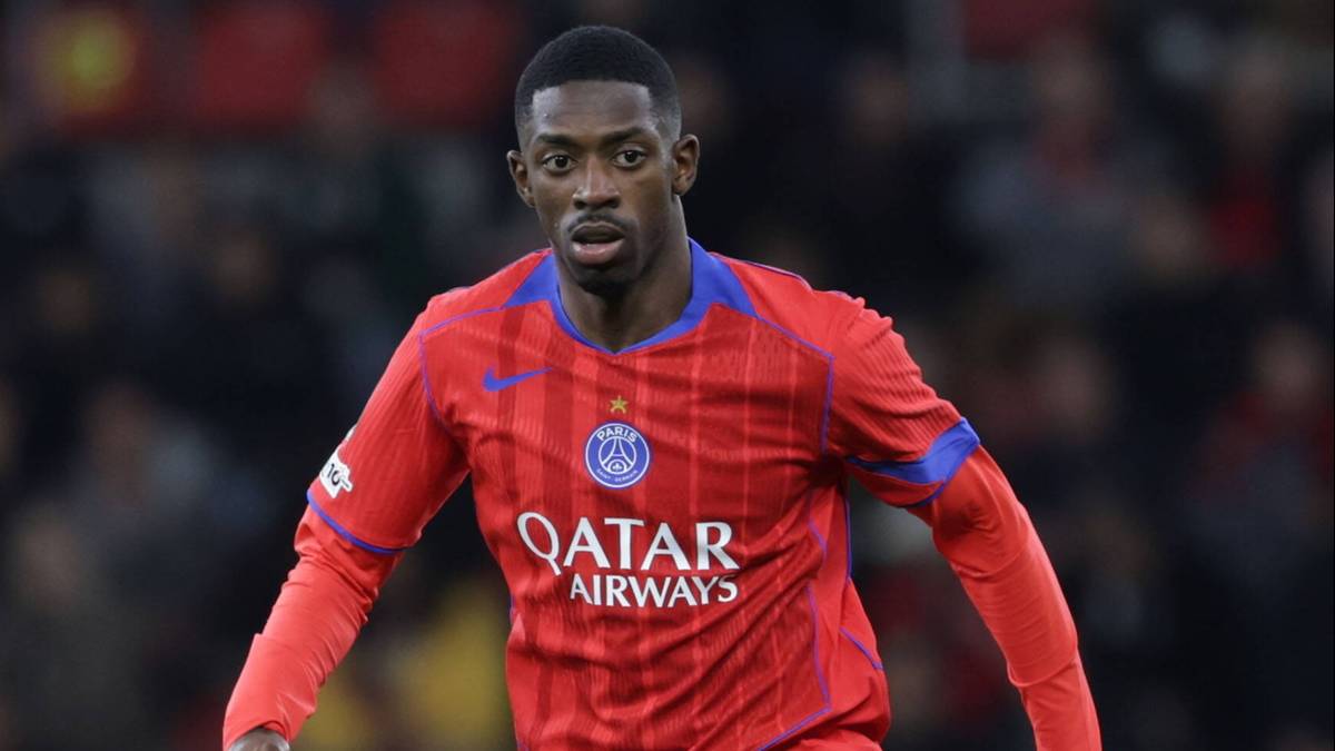 Piłkarz w czerwono-niebieskim stroju PSG prowadzi piłkę na murawie stadionu.