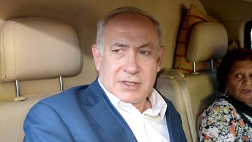 Benjamin Netanjahu siedzi w samochodzie, obok niego siedzi kobieta.