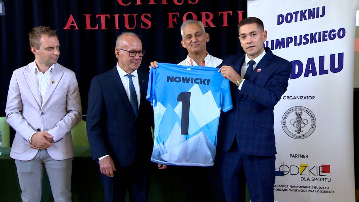 Czterech mężczyzn podczas ceremonii wręczenia koszulki z numerem 1 i nazwiskiem "NOWICKI".