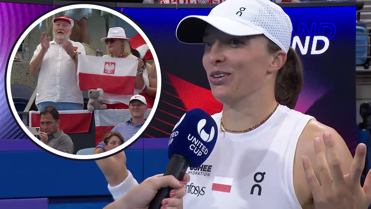 Iga Świątek udziela wywiadu na korcie, w tle widownia z polskimi flagami.