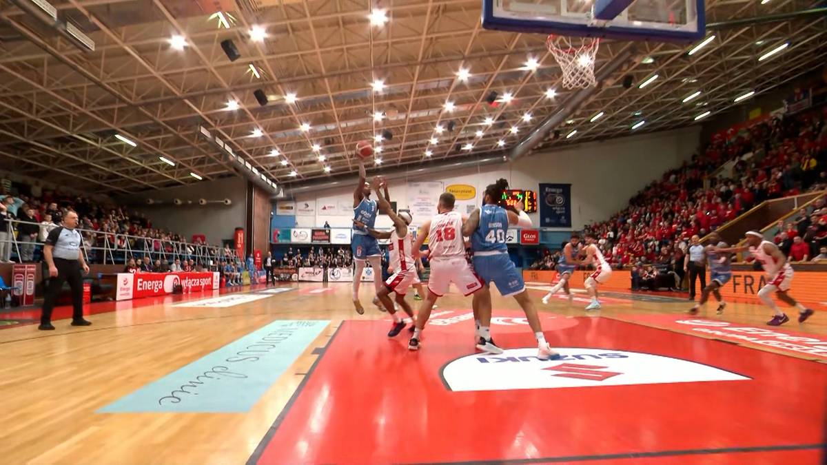 Zawodnicy walczący o piłkę pod koszem podczas meczu koszyk&oacute;wki.