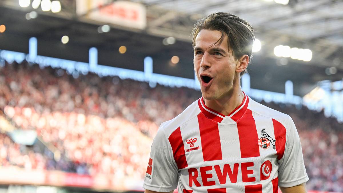 Piłkarz w koszulce z czerwono-białymi pasami krzyczy z otwartymi ustami.