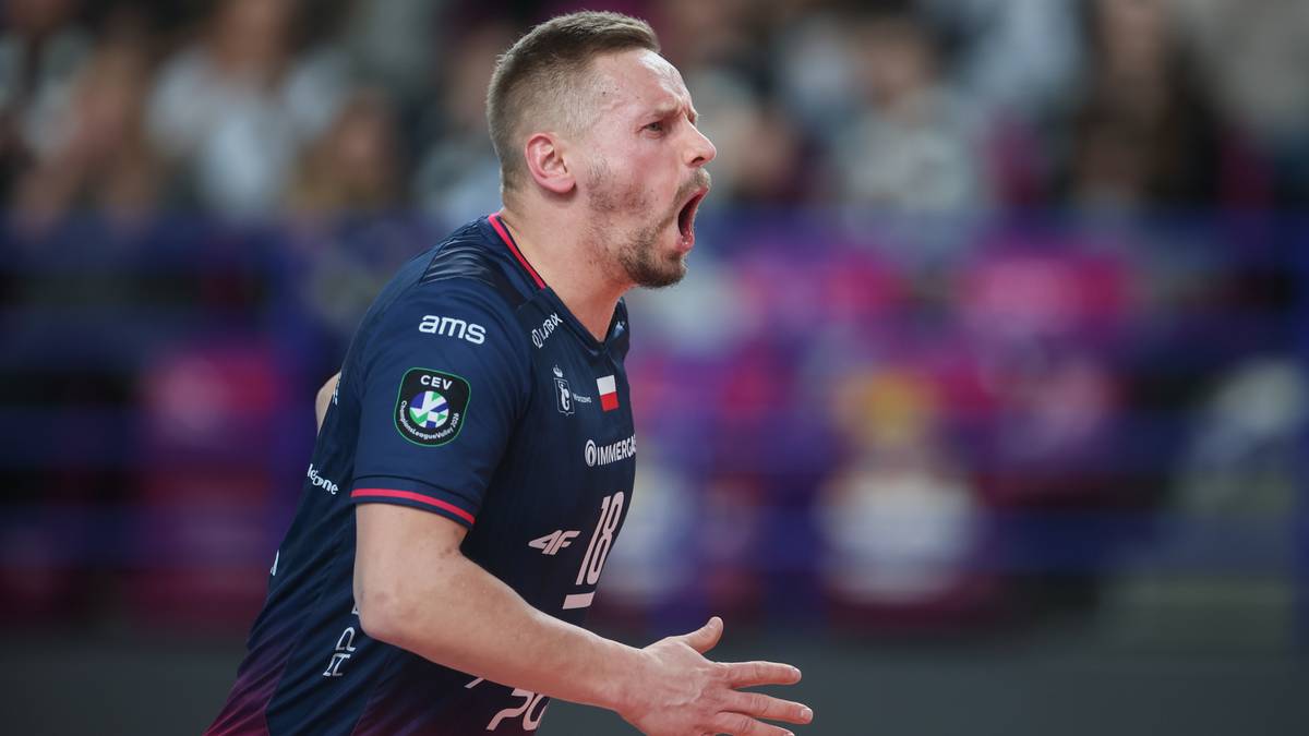 Damian Wojtaszek, siatkarz, w akcji podczas meczu, z otwartymi ustami i wyrazem twarzy pełnym emocji.