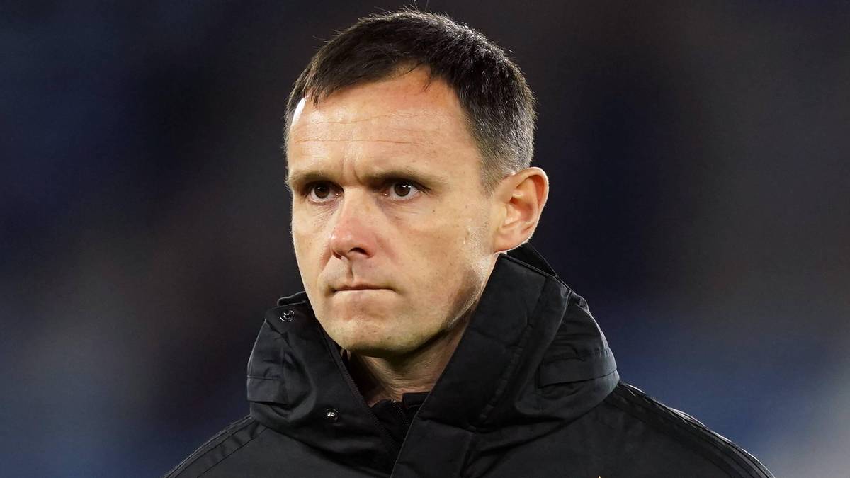 Trener Przemysław Małecki w czarnej kurtce sportowej z logo "L".