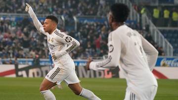 Dw&oacute;ch piłkarzy Realu Madryt w białych strojach świętuje bramkę na zielonym boisku.