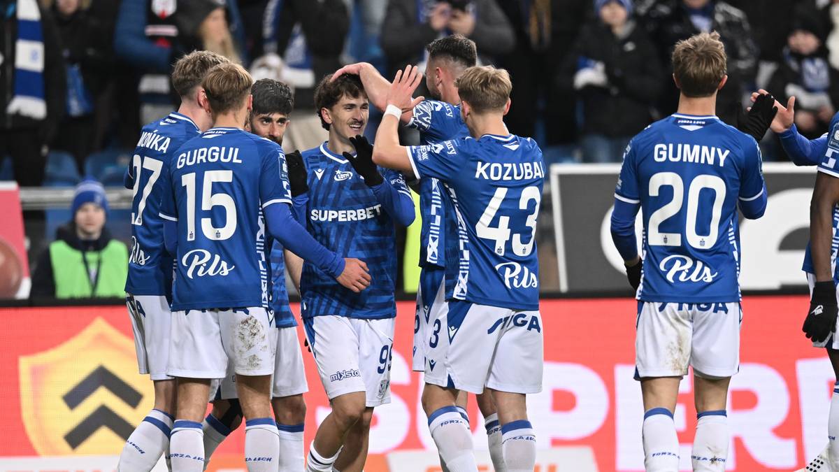 Piłkarze Lecha Poznań w niebieskich koszulkach świętują razem na boisku.