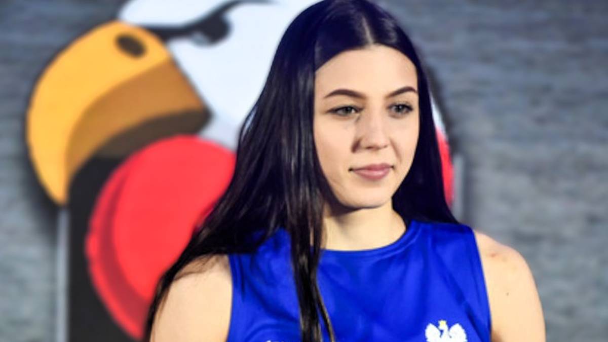 Młoda kobieta w niebieskiej koszulce sportowej z godłem Polski, w tle orzeł.