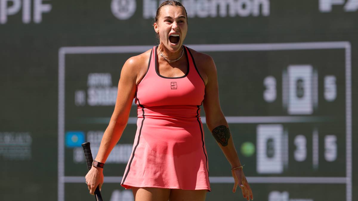 Aryna Sabalenka krzyczy z radości podczas meczu tenisowego, mając w ręku rakietę.