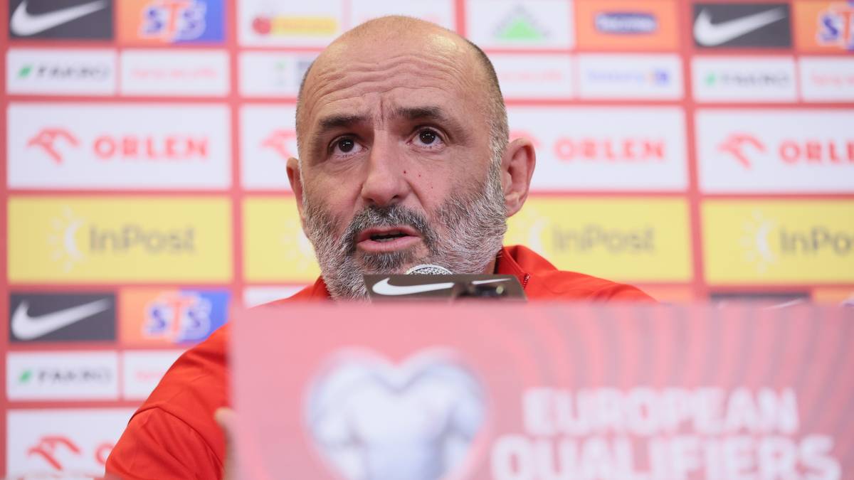 Michał Probierz, trener reprezentacji Polski, siedzi przy stole podczas konferencji prasowej.